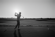 A black-and-white photo of a golfer mid-swing on a minimalist golf course, captured at sunrise or in soft light. The focus is on the smooth motion and form, not the player’s face — highlighting precision, control, and balance. This image conveys movement and mastery, perfectly matching your brand’s “designed for perfection” message.